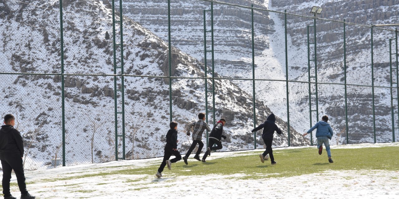 Şırnak'ta çocuklar futbol aşkına karlı yolları aşıp halı sahada top oynuyor