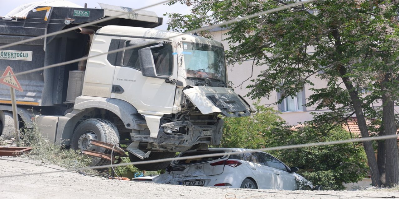 Hafriyat kamyonu otomobilin üzerine devrilmeye ramak kala duvarda asılı kaldı